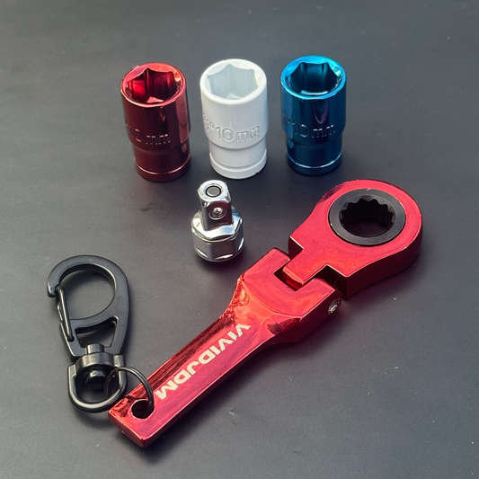 Set of mechanical tools including a red wrench and various sockets on a dark surface
